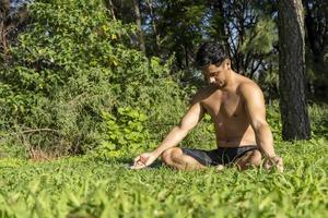 hispanic and latin man, meditating in the middle of a forest, receiving sun rays, brown skin, mexico photo