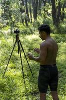 Guy with tablet making video blog on phone. Isolated person giving online classes. Man giving online classes with phone. photo