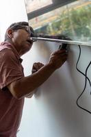 Mexican Latino man repairing a TV screen, checking for faults. photo