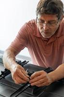 latin man putting a base for the television so that it can be attached to the wall photo