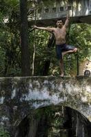 young man, doing yoga or reiki, in the forest very green vegetation, in mexico, guadalajara, bosque colomos, hispanic, photo