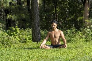 hispanic and latin man, meditating in the middle of a forest, receiving sun rays, brown skin, mexico photo