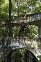 joven, haciendo yoga o reiki, en el bosque vegetación muy verde, en méxico, guadalajara, bosque colomos, hispano, foto