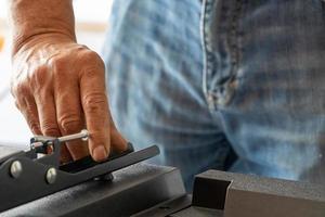 man installing the wall base for the television, it is a smart tv, adjusting with screwdriver photo