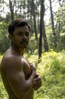 hombre visto de cerca, sin camisa haciendo estiramientos en colchoneta de yoga, ejercicio, américa latina foto