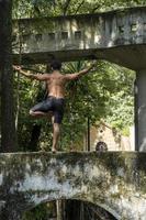 latin american man doing yoga posture, yoga posture, Bee backwards Prsthatah Brahmara, forest photo