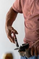 hombre latino buscando herramientas en su caja de herramientas, hispano, con destornillador en la mano foto