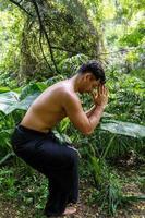 latin american man doing yoga posture, yoga posture, Bee backwards Prsthatah Brahmara, forest photo