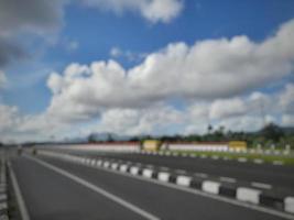 Resumen desenfocado de la carretera con fondo de cielo azul con pocas nubes foto