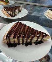 Pancake cake with chocolate and sour cream photo