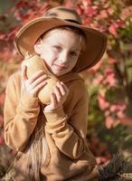 Girl in the hay with pumpkins photo