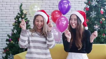 Two Asian woman celebrate Christmas party joyfully with festive sparklers. video