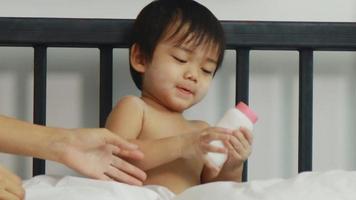 Asian moms and boys enjoy playing with baby powder at home. mother and son happy holidays