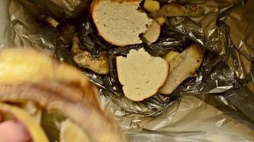 a man throws food waste into a small garbage container. video