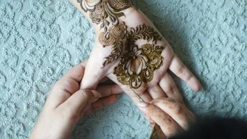 Henna artist paints design on a palm video