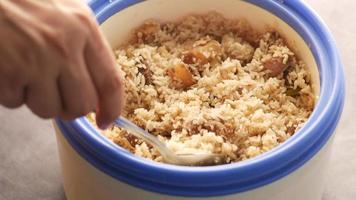 Person scoops rice and chicken out of dish with spoon video