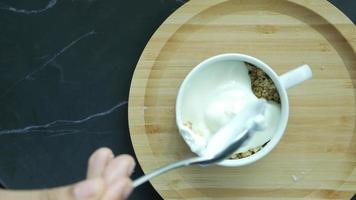 Granola and yogurt in a bowl and on table top video