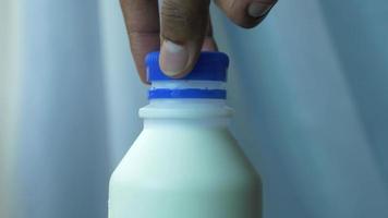 Removing the blue lid from a bottle of milk video