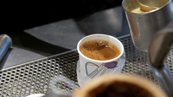 Kondensmilch wird hinzugefügt und am Tisch im Freien in heißen Kaffee eingerührt video