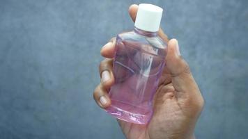Person hält eine durchsichtige Flasche Händedesinfektionsmittel video