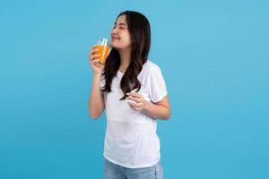 Beautiful woman drinking orange from a glass photo