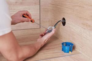 Electrician installing socket plug in the kitchen. Renovation concept photo