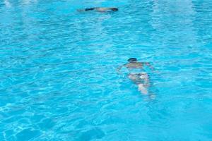 niño con máscara de buceo nadar bajo el agua en la piscina foto