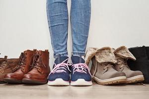 Woman chooses comfortable brown leather shoes among bunch of the different pairs photo