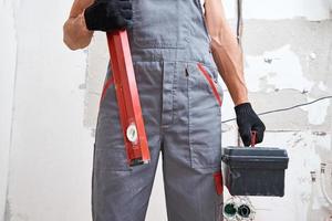 Builder man in uniform with construction tools. Repair concept photo