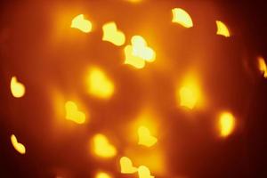 Abstract background with a golden blurred lights in heart shape. Valentine day concept photo