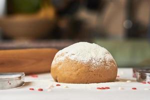 ball of raw dough sprinkled with flour on the table photo