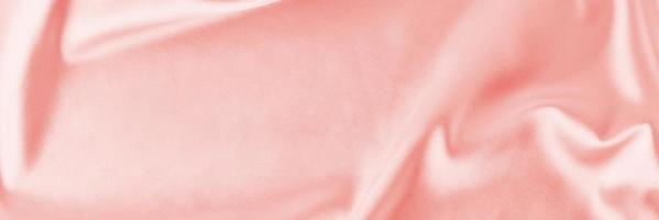 Light pink silk background with a folds. Abstract texture of rippled satin surface, long banner photo