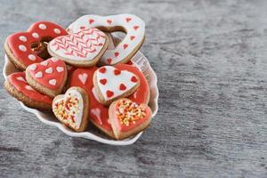 Decorated heart shape cookies in plate on the gray background. Valentines Day food concept photo