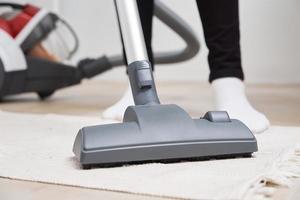 Woman use vacuum cleaner at the floor photo