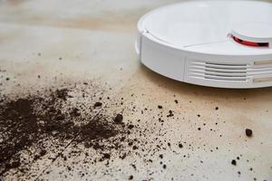 Robot vacuum cleaner cleans dirt on floor. Smart home concept photo