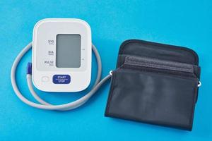 monitor de presión arterial digital sobre un fondo azul, primer plano. salud y concepto médico foto