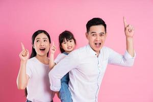 happy young asian family image, isolated on pink background photo