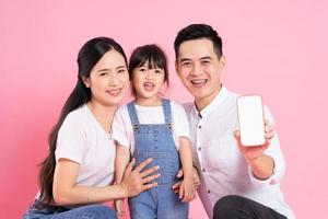 happy young asian family image, isolated on pink background photo