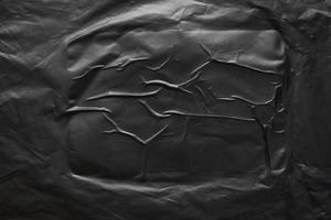 transparent plastic bag wrap overlay texture on black background photo
