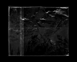 Blank transparent plastic bag overlay on black background photo