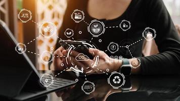 Businesswoman working virtual tablet computer twith reduce CO2 concept with icons global warming such as reforest green factory recycle and zero carbon dioxide emission concept. photo