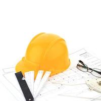 Architect's desk and tools have a yellow safety helmet. photo