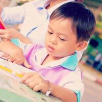 A mother in a nursing uniform is teaching her son homework. photo