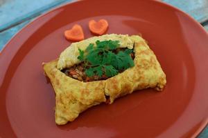 stuffed omelette, Omelet with vegetable salad and Heart-shaped carrot, on blue old wooden photo