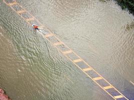 Flooded roads, people with cars running through. Aerial drone photography shows streets flooding and people's cars passing by, splashing water. photo