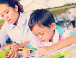 A mother in a nursing uniform is teaching her son homework. photo