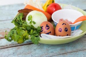 Fresh vegetables, eggs and pork chops. On blue wooden photo