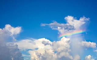 las nubes blancas tienen arco iris de colores en el cielo azul brillante durante el día. foto