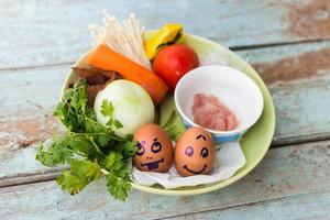 Fresh vegetables, eggs and pork chops. On blue wooden photo