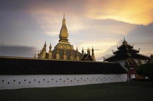 Laos Travel Landmark, Golden Chedi, Wat Phra That Luang at sunset in Vientiane photo